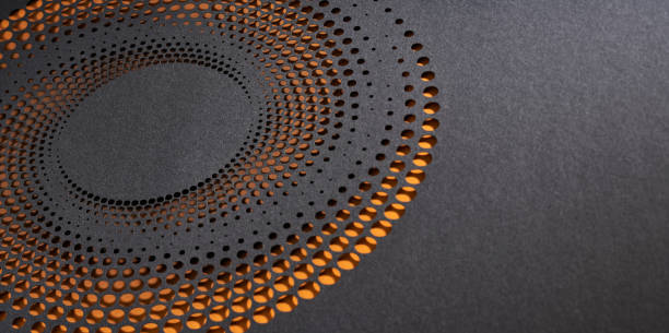 istock Intricate circular cut paper artwork featuring a gradient of perforated holes on dark textured surface with an orange backdrop. 2171361588
