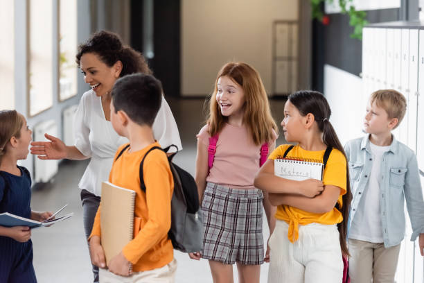 istock Multicultural schoolchildren joyfully interacting in a modern hallway during the school day 2171361891