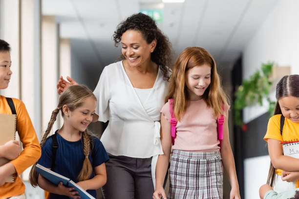 istock Multicultural schoolchildren joyfully walking through a modern school hallway together 2171361938