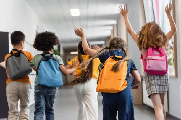 istock Multicultural schoolchildren joyfully walking together in a vibrant, modern school hallway 2171361939