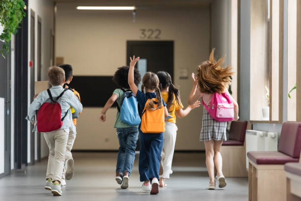 istock Multicultural schoolchildren joyfully walking down a bright hallway in a contemporary school 2171362061
