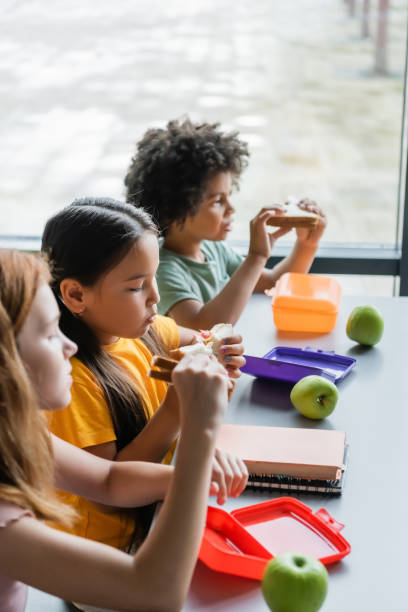 istock Multicultural kids enjoy nutritious lunches from reusable containers in a bright classroom 2171362625