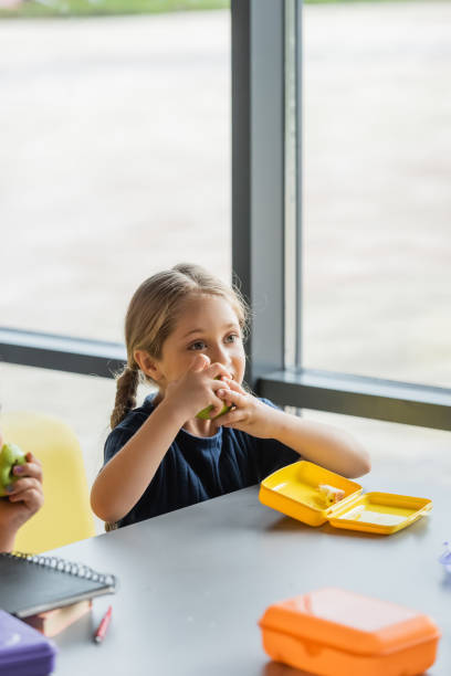 istock blonde girl enjoying apple for lunch 2171362792