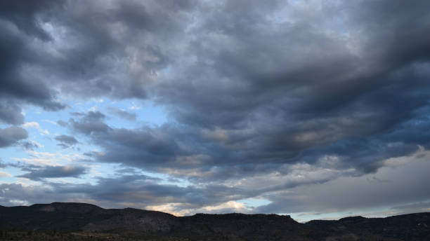 istock Dramatic afternoon sky with clouds over a silhouette of mountains on the horizon 2171363039