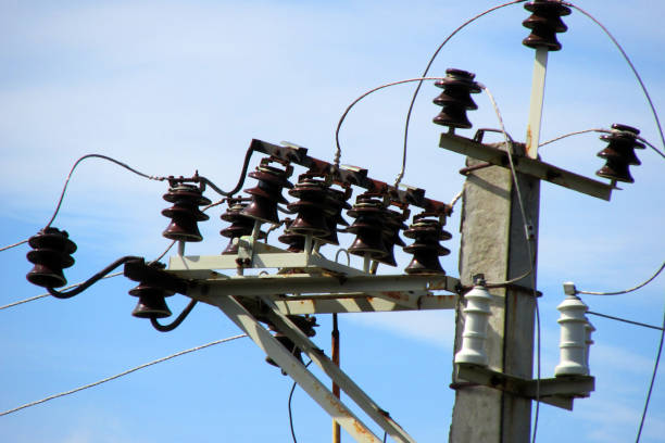 istock Electrical cables and ceramic, porcelain insulators of high voltage transmission line on top of concrete pole 2171365488