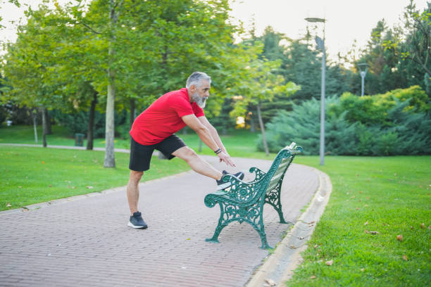 istock white haired man in red tshirt stretching in the park 2171368388
