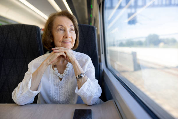 istock Senior woman riding on a train and looking through the window 2171370768