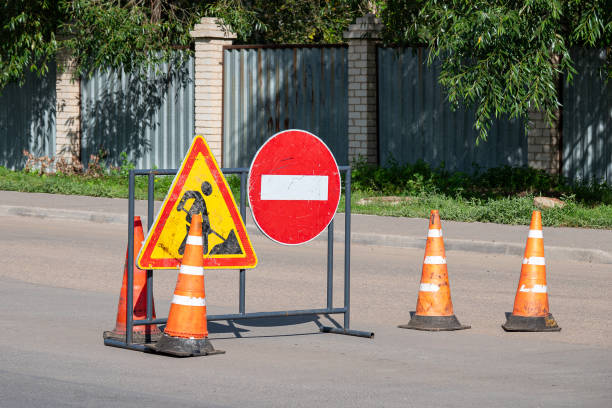 istock Road construction warning signs and orange traffic cones blocking access 2171377509