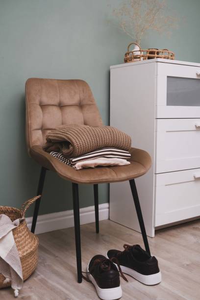 istock A stylish and cozy corner featuring a comfortable chair alongside essential clothing items 2171378573