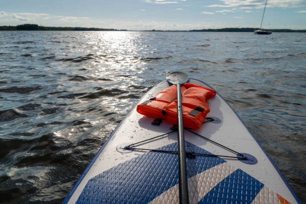 istock Paddleboard resting on water with a life vest beside it 2171378677
