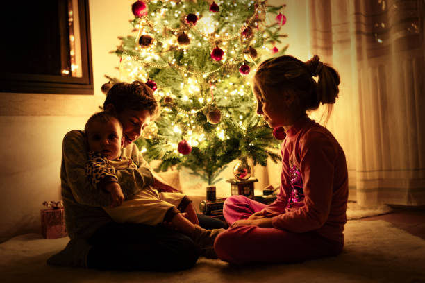 Children next to a Christmas Tree Enjoy Christmas Time