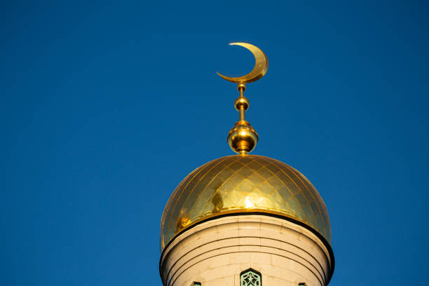A magnificent gold dome features a beautifully crafted crescent moon finial perched gracefully atop it, symbolizing elegance and spirituality