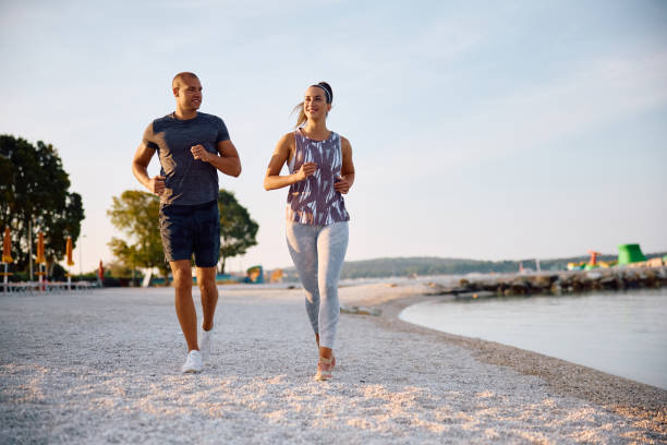 istock Happy athletic friends jogging on the beach. 2171383982