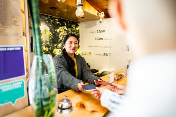 Receptionist catching tourist passports on a hotel