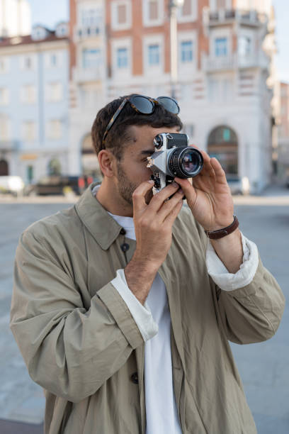 istock Young, upscale man takes photos in town square 2171390864