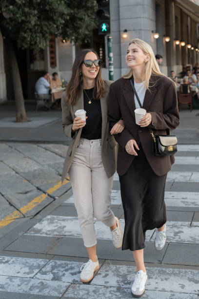 istock Young, upscale girlfriends walk across sidewalk 2171390991