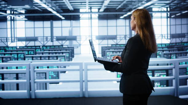 istock IT specialist in server hub monitoring server infrastructure using notebook 2171394059