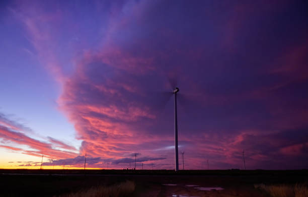 istock A single wind turbine silhouetted against a dramatic sunset sky over a vast field 2171394922