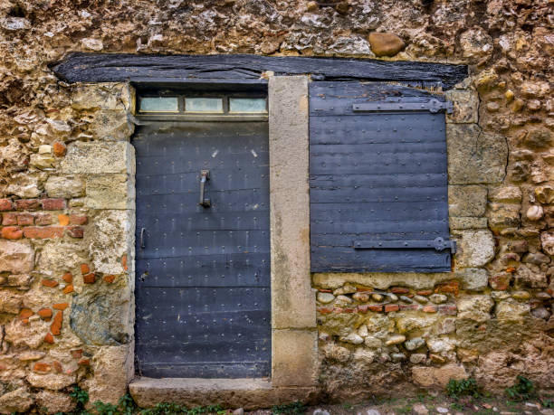 Architectural detail from Perouges (Pérouges) which is a commune in the Ain department in the Auvergne-Rhône-Alpes region in Eastern France. A medieval walled town perched on a small hill that overlooks the plain of the river Ain, it is located 30 km northeast of Lyon, historically in the neighbouring Rhône department. Pérouges, France is thousands of years old, with archaeological evidence of human presence dating back to the Chalcolithic age (around 2500–1800 BC).