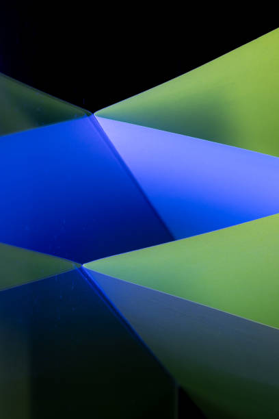Sharp angles and vivid hues in different blue, yellow and green tints combine to form a captivating abstract composition, showcasing the beauty of geometry in art. The striking contrasts draw viewers into the vibrant interplay of colors.