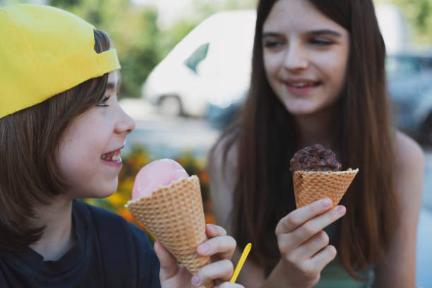 istock Two happy friends eating ice cream in a park 2171408097