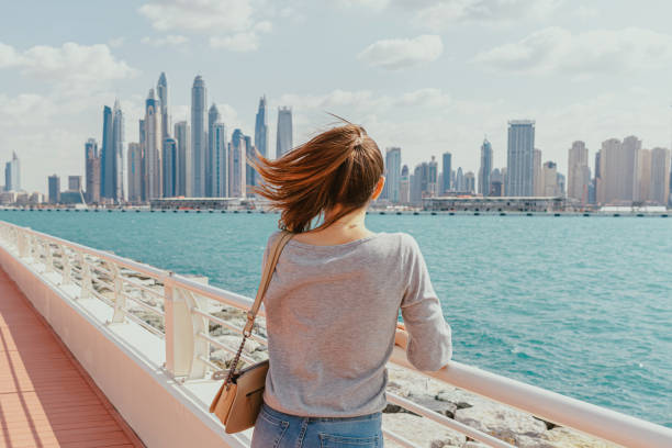 istock Woman overlooking the city skyline from a waterfront walkway 2171416347