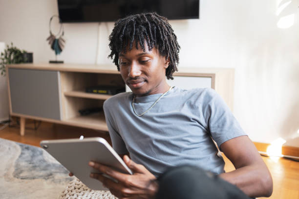 istock Young man relaxing at home with a digital tablet 2171418052