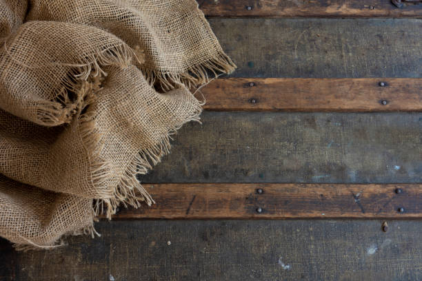 An abstract image of a burlap sack on top of a vintage steamer trunk lid.
