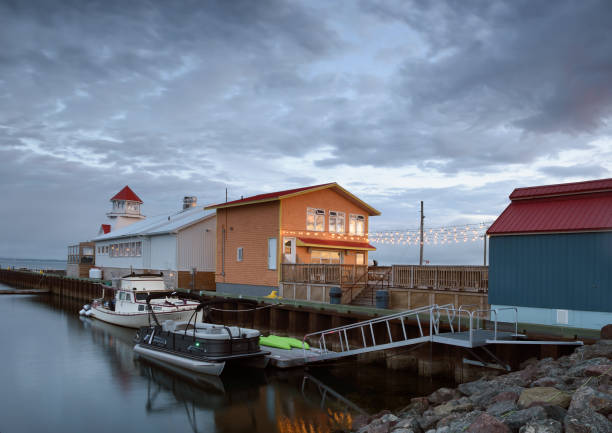 Canada, Shediac - August 22, 2024: Shedia harbor with tour boat, fishing boat, restaurants and stores on the pier at sunrise. Shediac is considered as one of the most important Acadian region and of course, the lobster capital