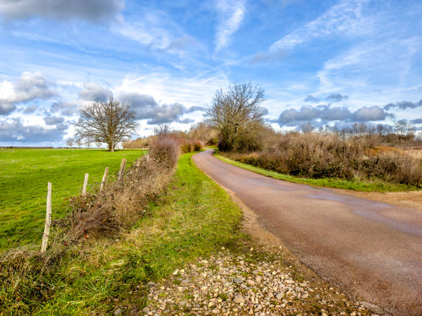 istock Empty dirt road in rural landscape over sky 2171429544