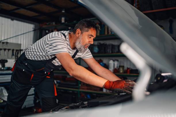 istock Professional mechanic in uniform fixing broken car under the hood. 2171430245