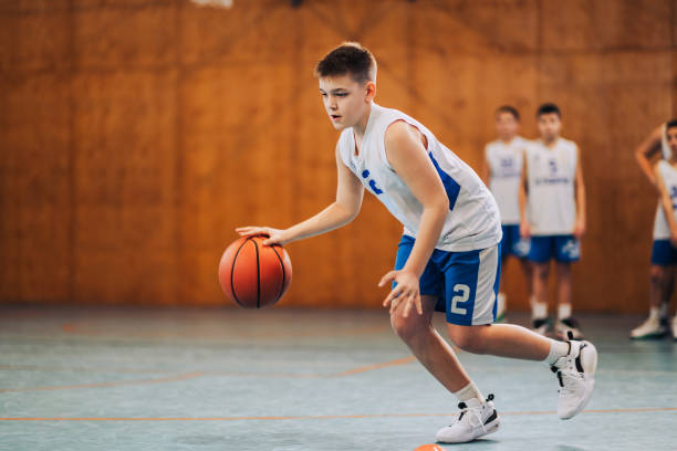 istock Basketball player dribbles with intent on court 2171430247