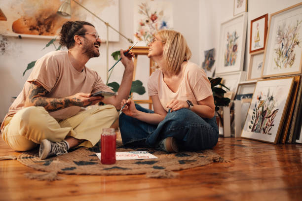 istock Happy affectionate painter couple sitting on atelier floor and having fun. 2171430313