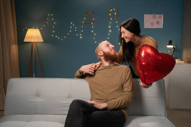 istock Romantic couple celebrating with heart-shaped balloon 2171433986