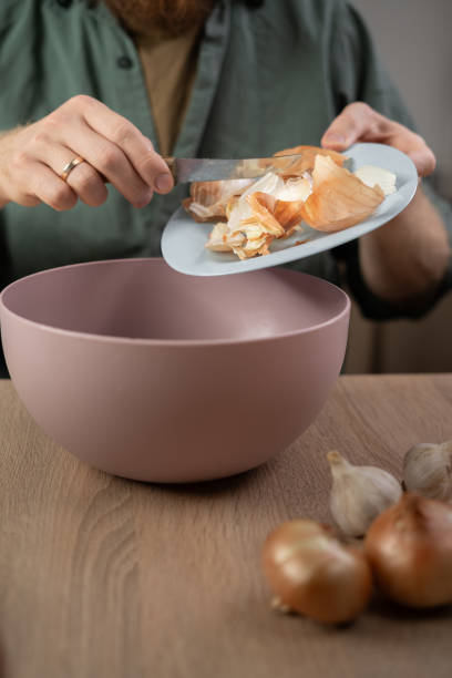 istock man throws vegetable peels, scrap from food preparation in plastic bowl for recycling 2171434073