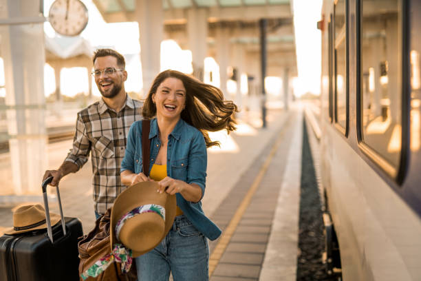 istock Young couple running to catch a train on train station. 2171436425