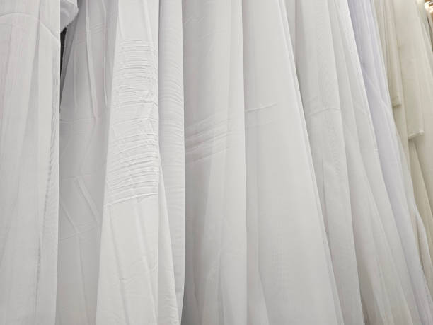 istock White sheer fabric hanging in a textile shop showcasing various textures and patterns during daylight hours 2171438436
