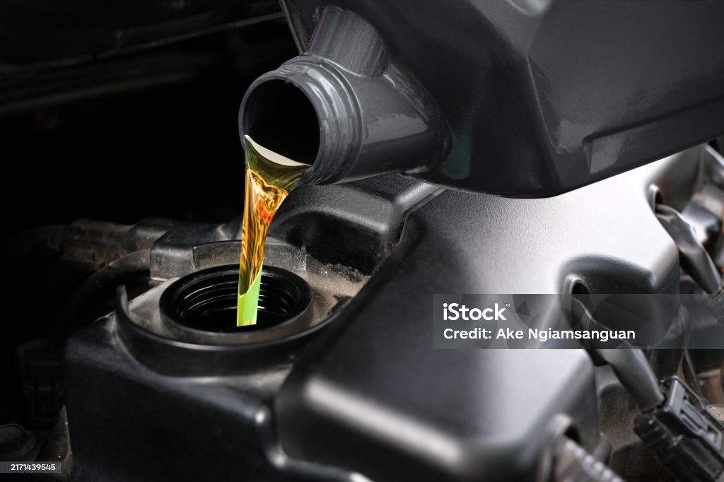 Refueling and pouring oil quality into the engine motor car Transmission and Maintenance Gear.Energy fuel concept Oil Change Stock Photo Refueling and pouring oil quality into the engine motor car Transmission and Maintenance Gear.Energy fuel concept Oil Change Stock Photo