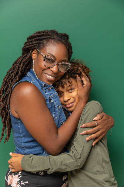 istock Beautiful young black boy and his mother posing for studio portrait 2171441199