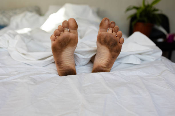 istock Dirty feet in white sheets symbolize sloppiness 2171443020