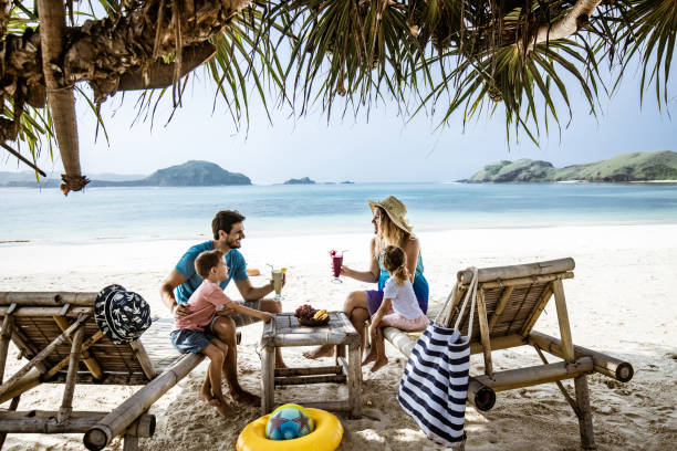 istock Happy family talking while relaxing on deck chairs at the beach. 2171448156