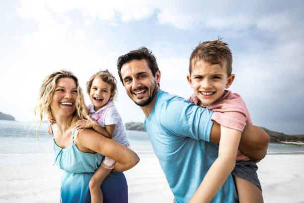 istock Playful family having fun while piggybacking on the beach. 2171448298