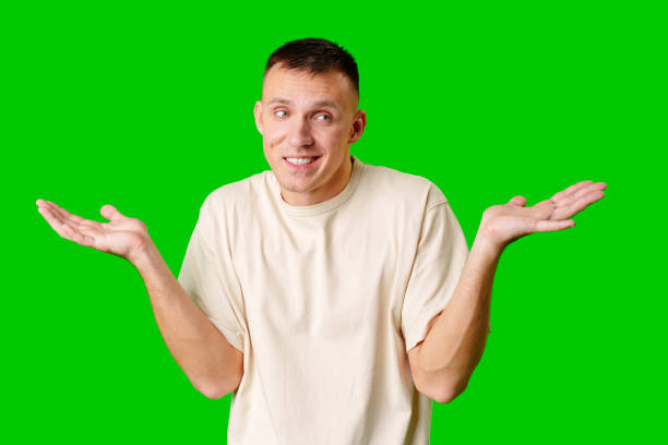 istock Young Man With Neutral Expression Shrugging His Shoulders Against Bright Green Background 2171448303
