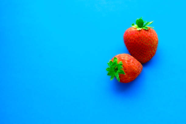 red ripe strawberries isolated on a blue background