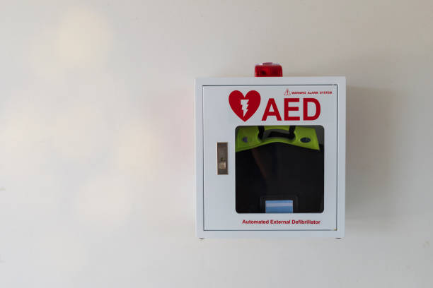 Automated External Defibrillator medical first aid device on white wall. Portable electronic device that automatically diagnoses the life-threatening cardiac arrest. AED box.