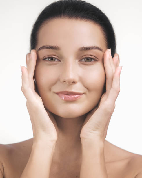 istock Beautiful Woman Practicing Skincare Routine with Hands on Face 2171449332