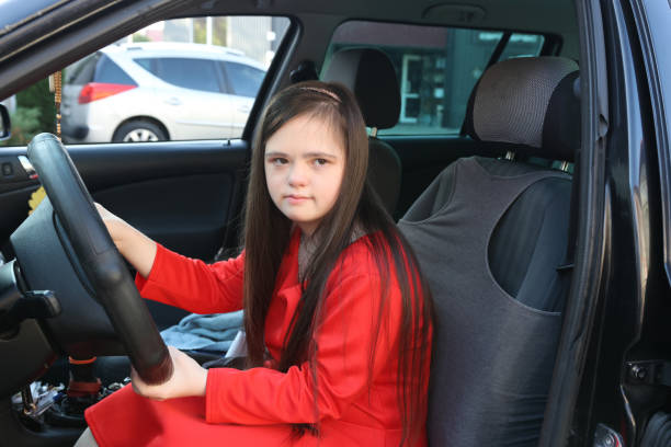 istock A girl with Down syndrome driving a car. 2171449606