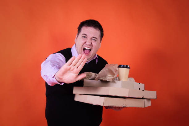 Funny hungry fat man on a diet is dissatisfied with a small pizza.