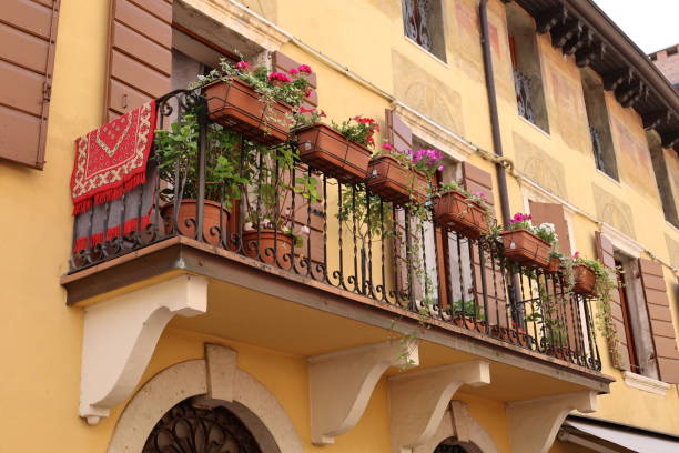 Facade of a residential apartment building with windows and a balcony in the old town of Verona.