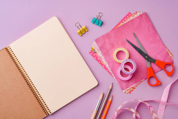 istock Scissors and decorative tape on colorful craft paper in a bright workspace 2171450330